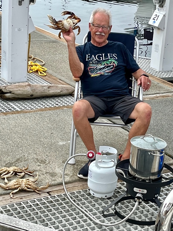 Jeff smiling on the dock, holding up a freshly caught crab